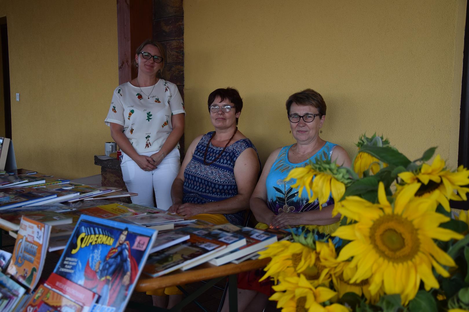 Zdjęcie przedstawiające pracowników bibliotek przy stoisku książkowym