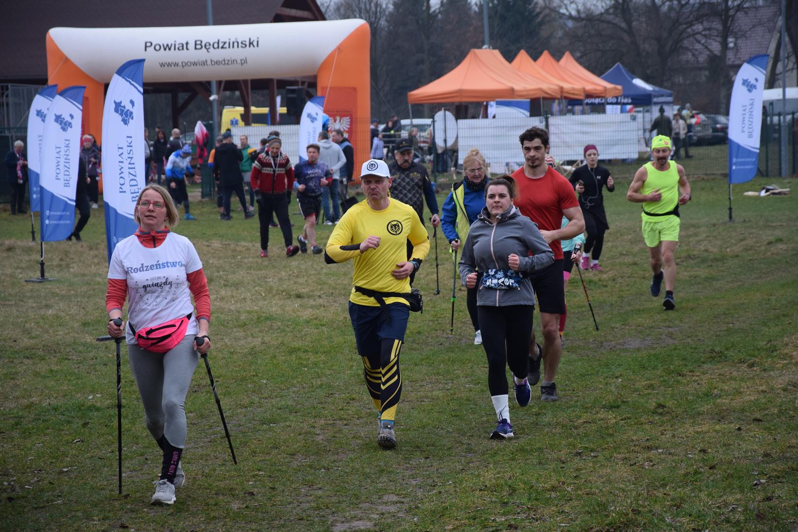 Zdjęcie przedstawia uczestników imprezy podczas biegu