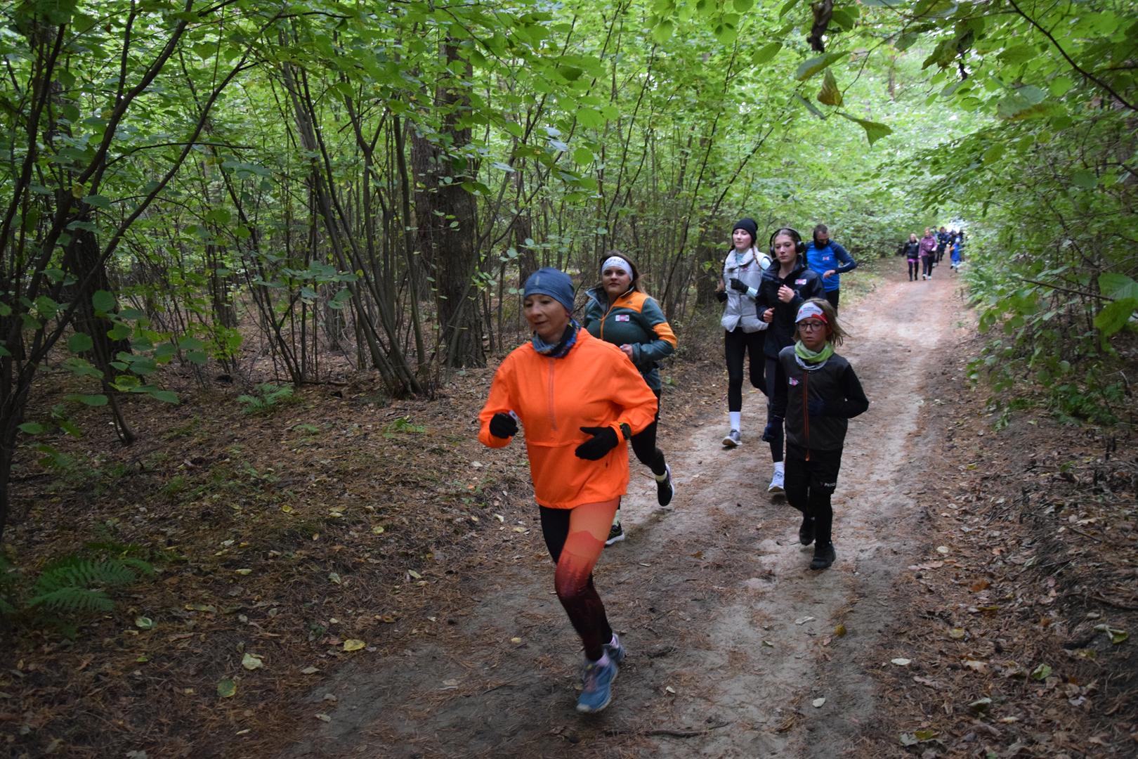 Zdjęcie przedstawia uczestników wydarzenia na trasie biegu