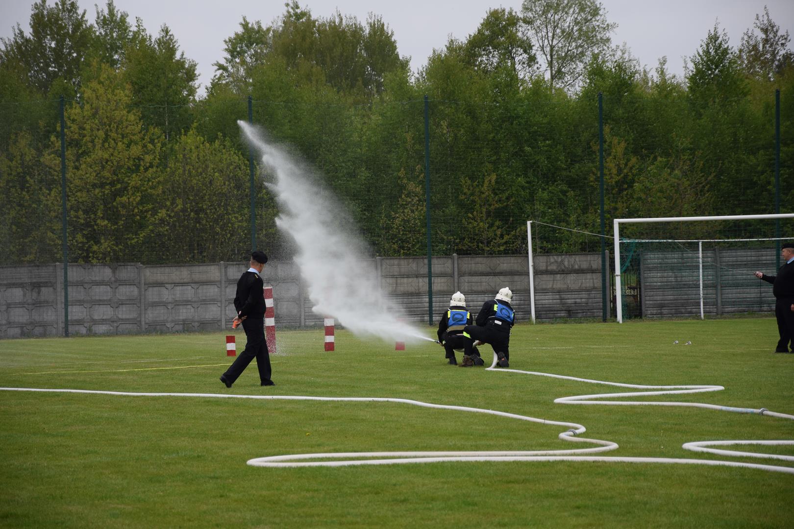 Zdjęcie przedstawiające strażaków podczas wykonywania konkurencji sportowo-pożarniczych