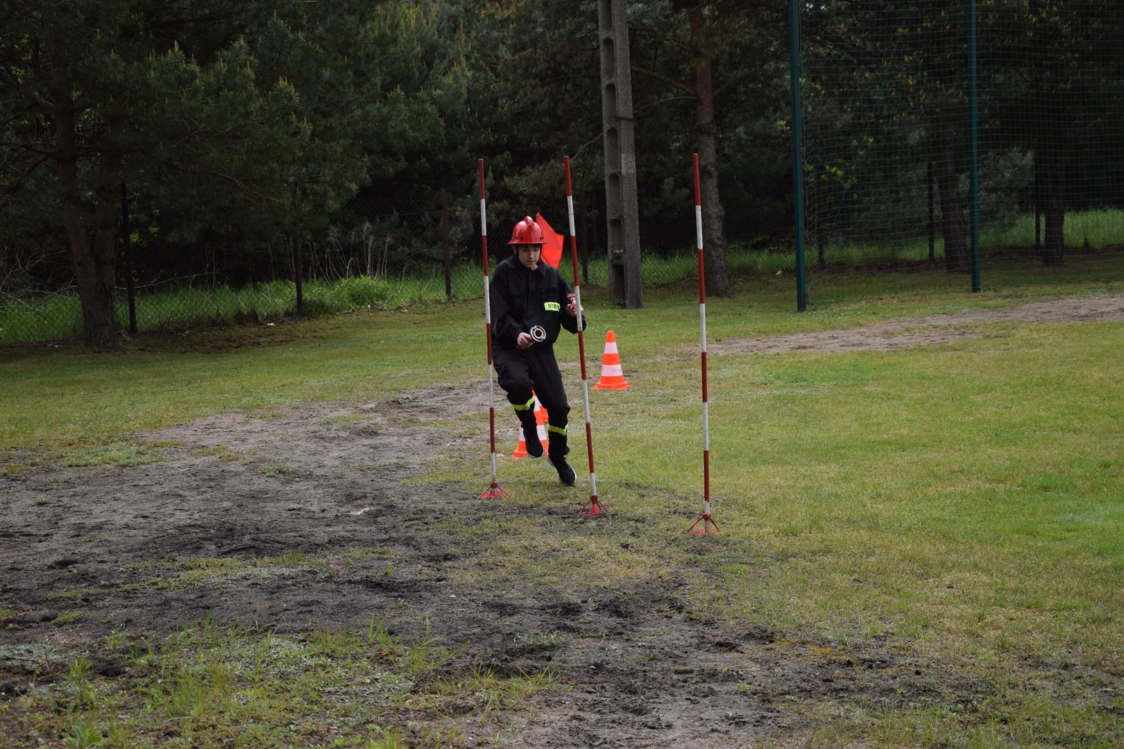 Zdjęcie przedstawiające strażaków podczas wykonywania konkurencji sportowo-pożarniczych