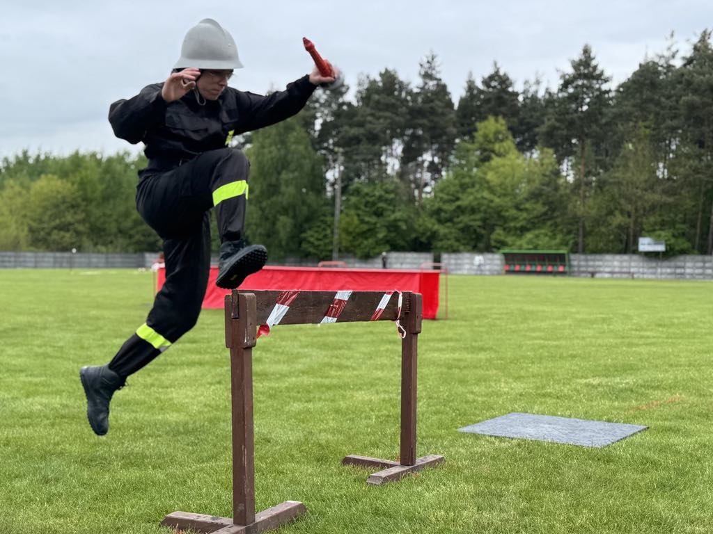 Zdjęcie przedstawia strażaków biorących udział w zawodach sportowych