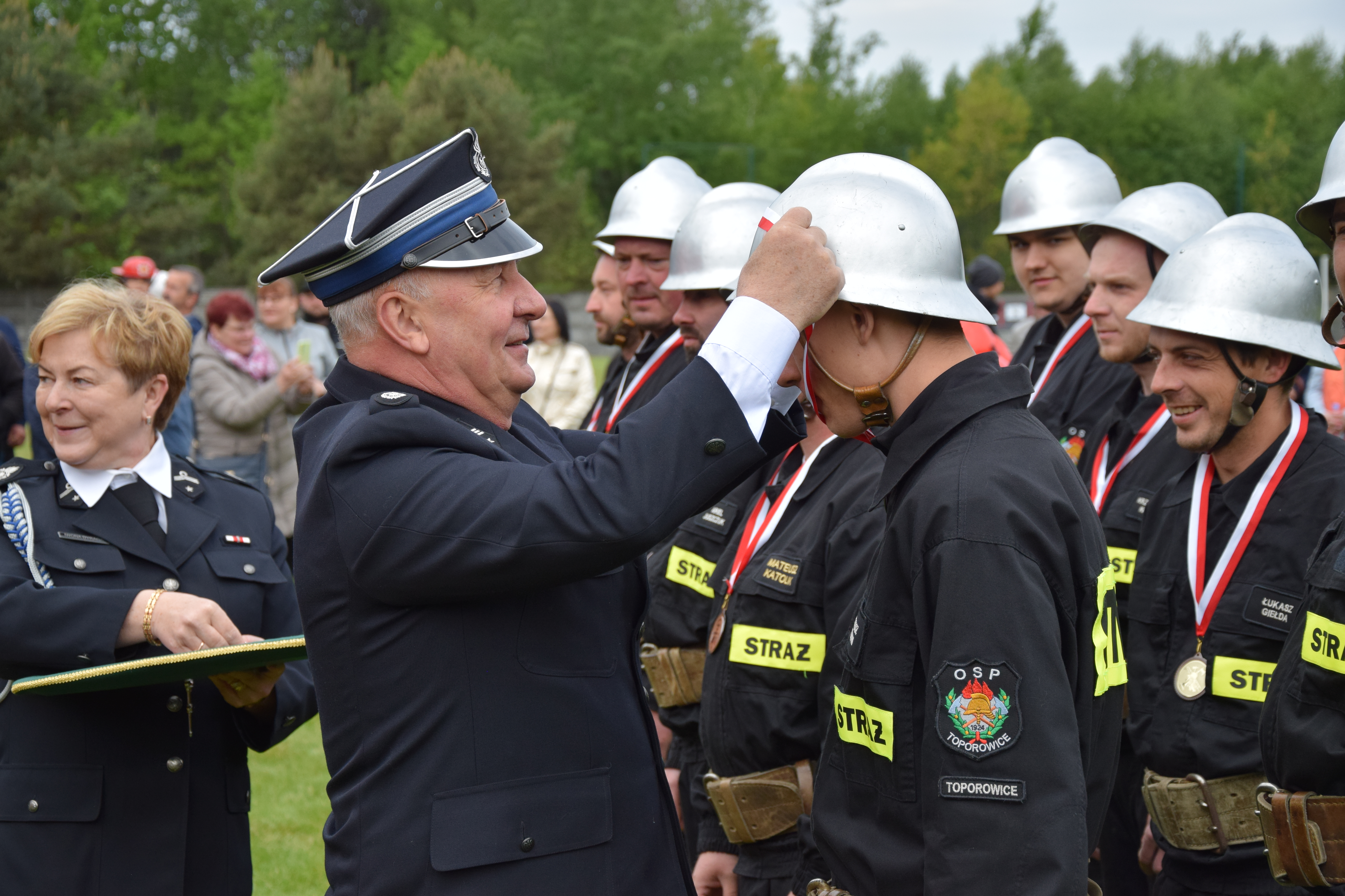 Zdjęcie przedstawia moment wręczenia odznaczeń i wyróżnień