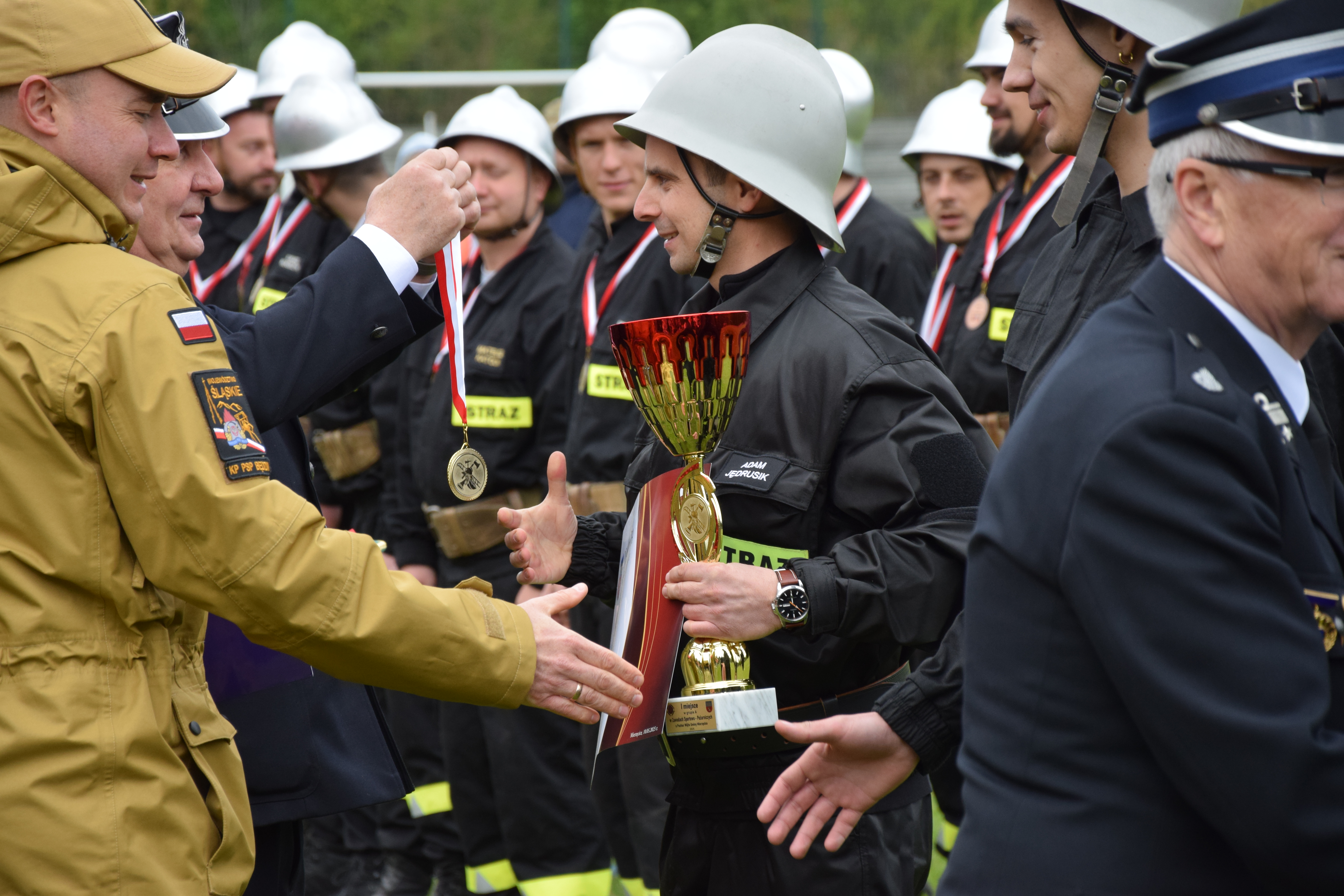 Zdjęcie przedstawia moment wręczenia odznaczeń i wyróżnień