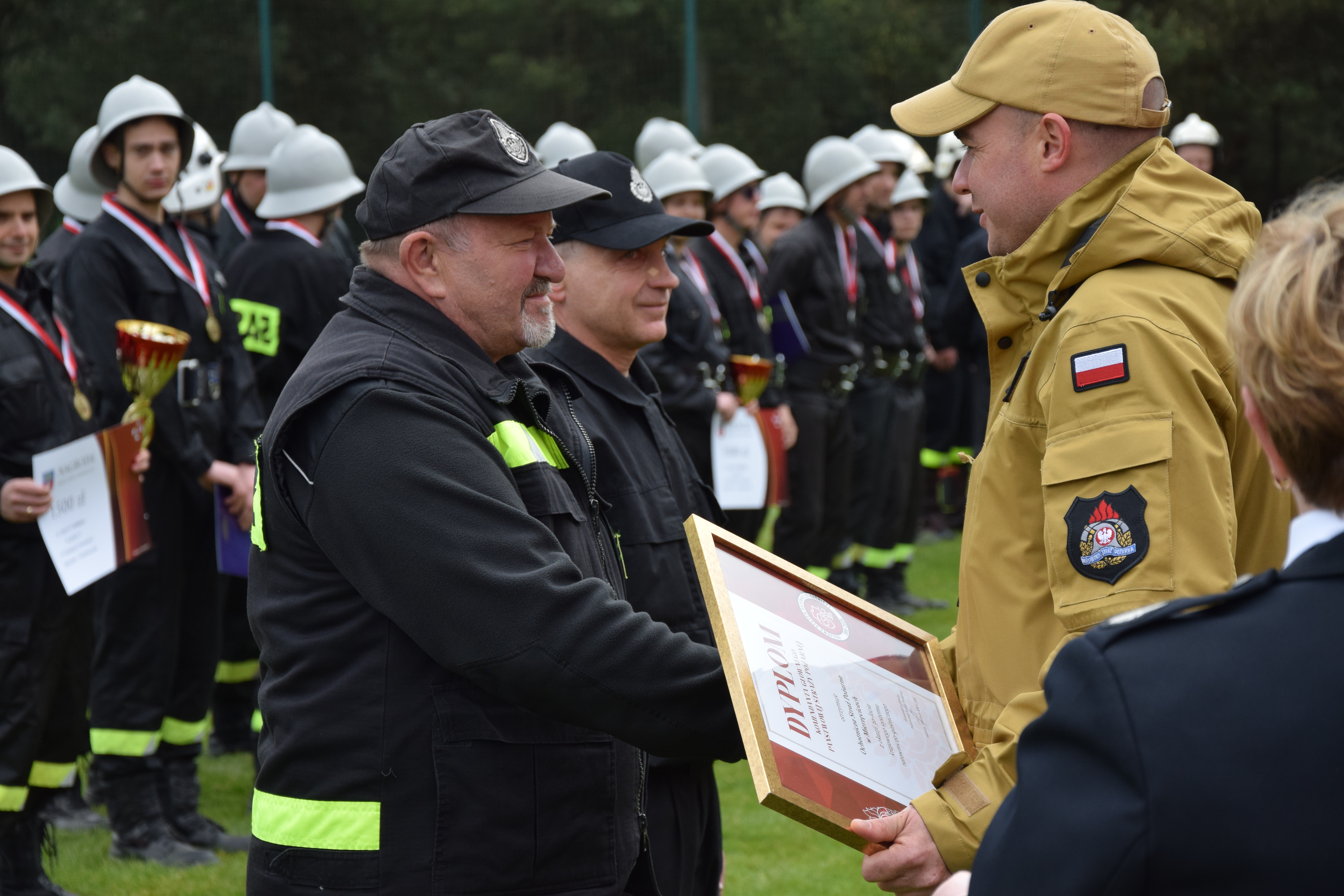 Zdjęcie przedstawia moment wręczenia odznaczeń i wyróżnień