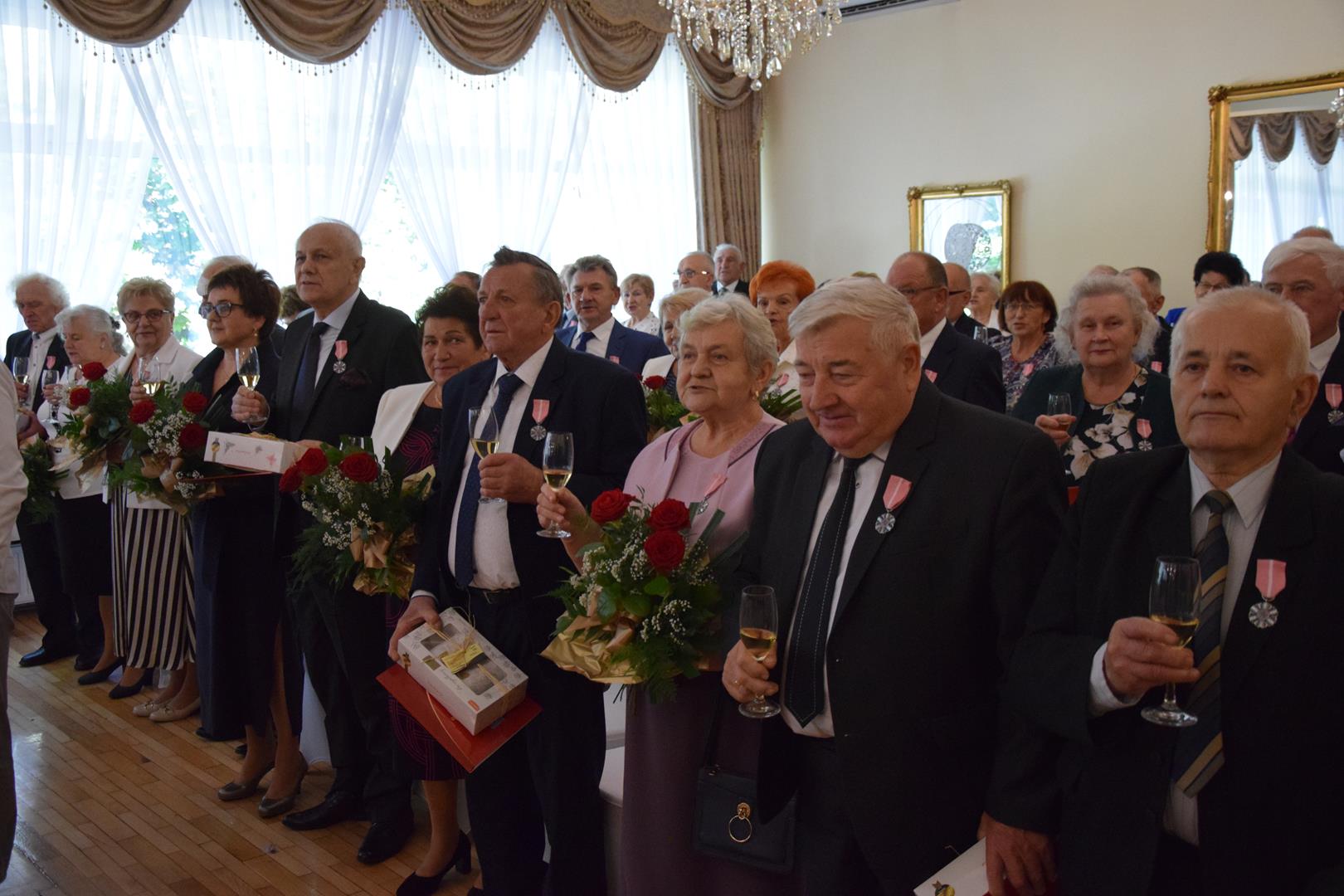 Zdjęcie przedstawia moment wzniesienia toastu