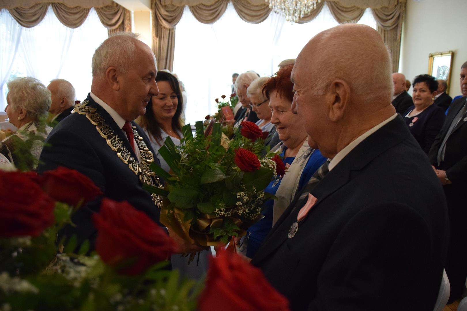 Zdjęcie przedstawia moment rozdania medali i legitymacji