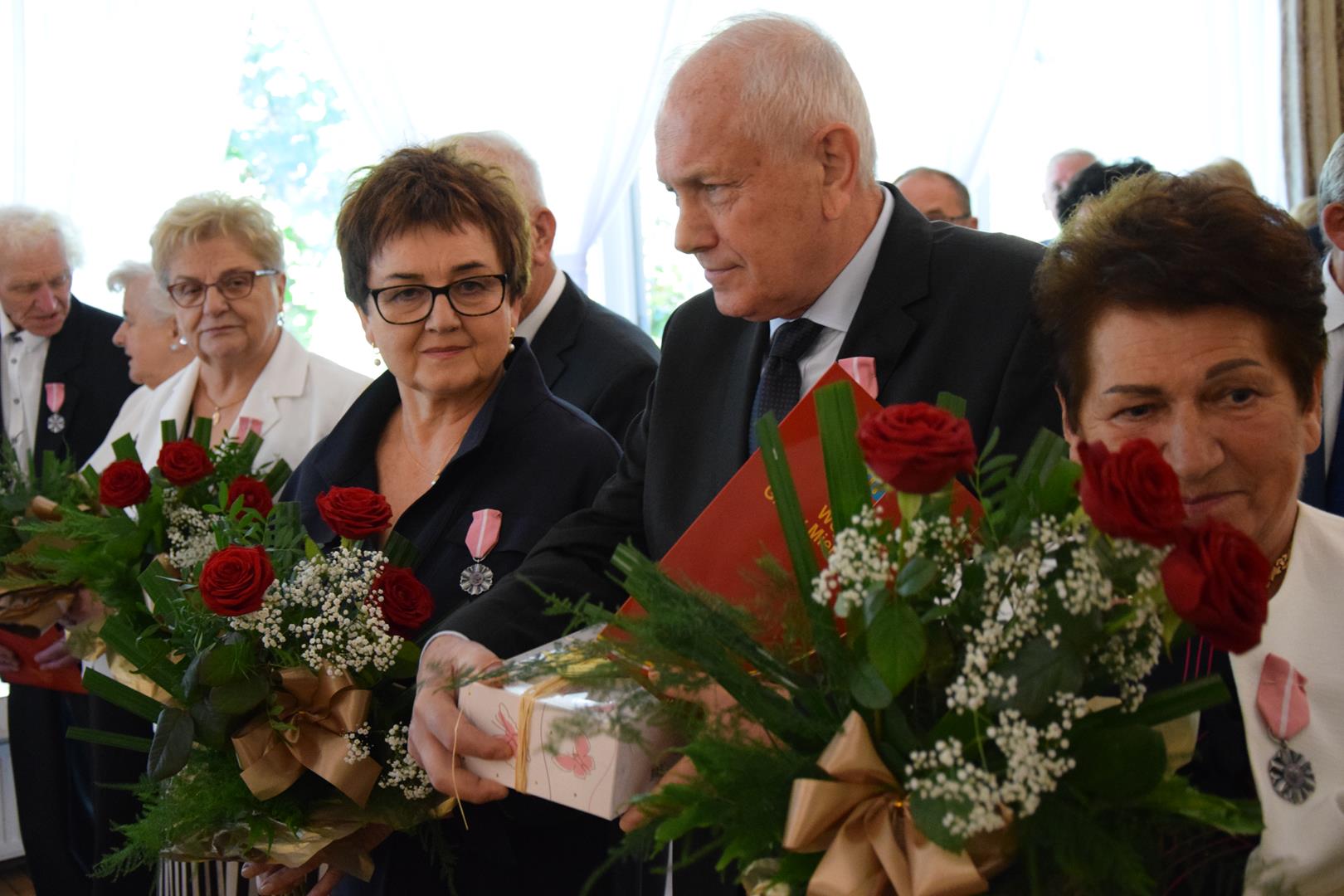 Zdjęcie przedstawia moment rozdania medali i legitymacji