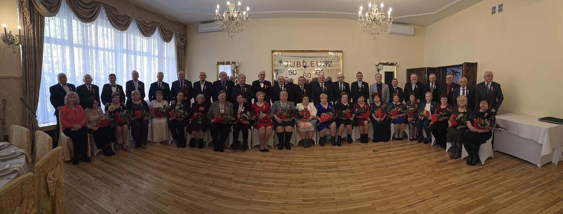 Zdjęcie przedstawiające jubilatów pozujących do zdjęcia grupowego